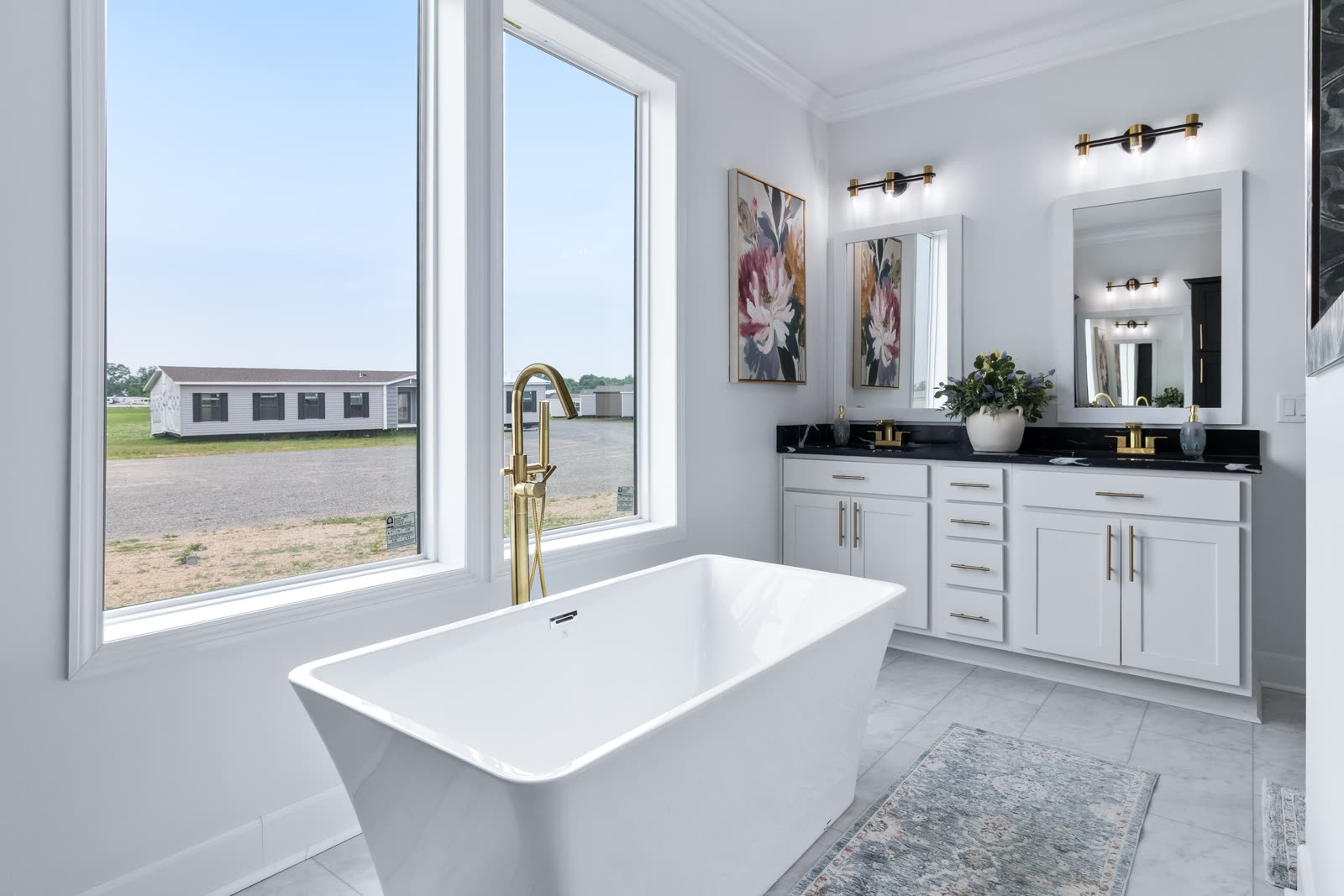 Primary bath with a freestanding tub beside tall windows