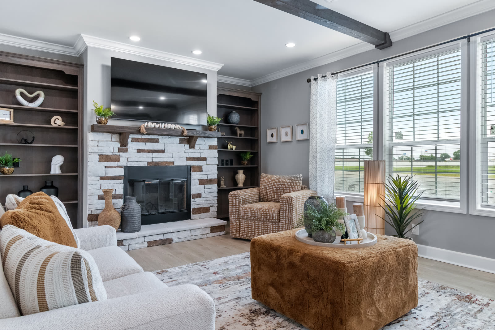 Living room with a stone fireplace wall and built-in shelves